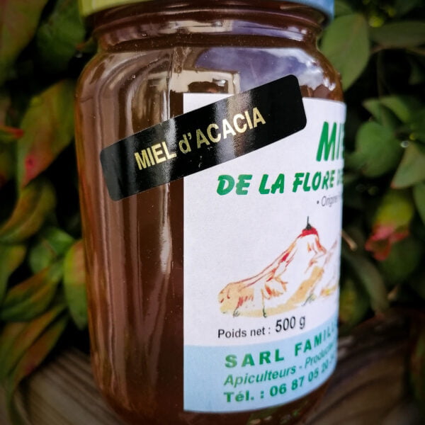 Vue de côté d'un pot de miel d'acacia de 500g de la flore des Pyrénées produit par la famille Legrand à Bégole dans les Hautes-Pyrénées