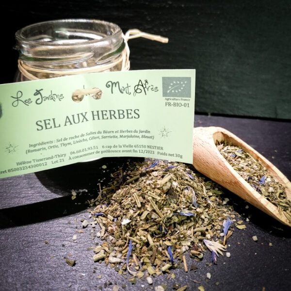 Petit pot de sel aux herbes de 30g des jardins Mont Arès posé sur une ardoise avec une petite cuillère à sel et épices.