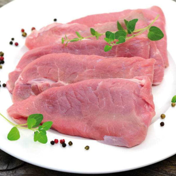 Cinq superbes escalopes de veau posées dans une assiette blanche avec des grains de poivres et plantes aromatiques.