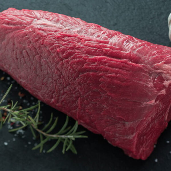 joli steak d'épaule de bœuf posé sur une ardoise avec du romarin et des grains de sel.
