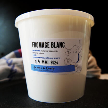 Grand pot de fromage blanc sur un décor noir