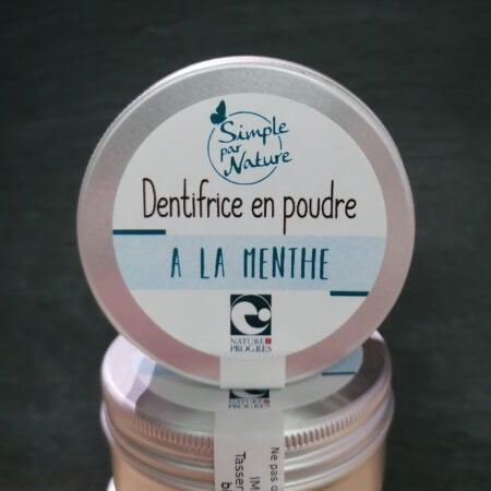 Photo vue de face d'un pot de dentifrice en poudre à la menthe produit par simple par nature dans les pyrénées, ce pot est posé sur d'autres pots et le fond de la photo est noire