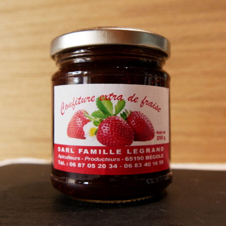 Pot de confiture de fraises de 250g posé sur une plaque noire