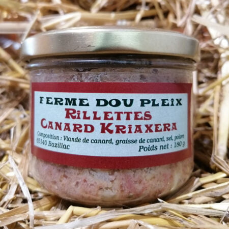 Pot de rillettes de canard Kriaxera posé sur de la paille et produit par la Ferme Dou Pleix à Bazillac dans les Hautes-Pyrénées. le pot fait 180g