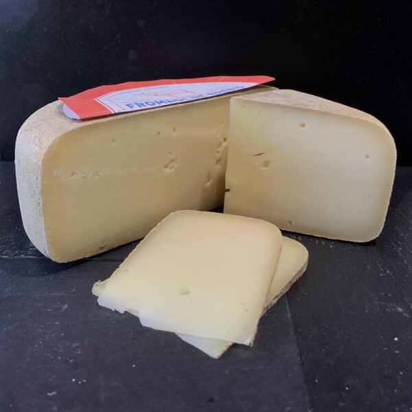 Tomme de fromage de brebis avec un cinquième coupé sur le coté et quelques tranches à l'avant