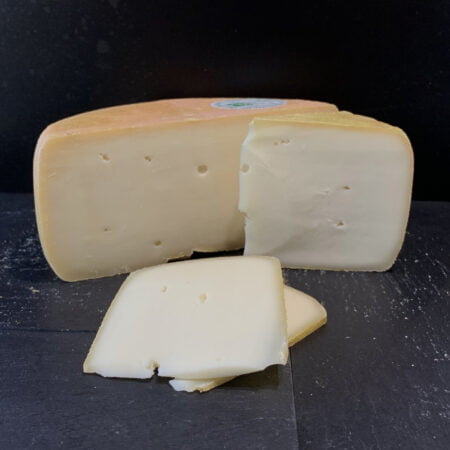 Tomme de chèvre de chez Monsieur Lebbe coupée un première fois à moitié, puis un cinquième, et enfin deux tranches à l'avant