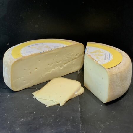 Fromage de vache en tomme avec un tiers et deux tranches coupés