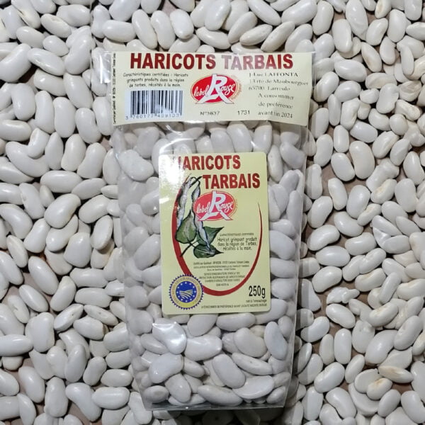 Photo d'un paquet de Haricots Tarbais Label Rouge IGP posé sur un lit de Haricots Tarbais
