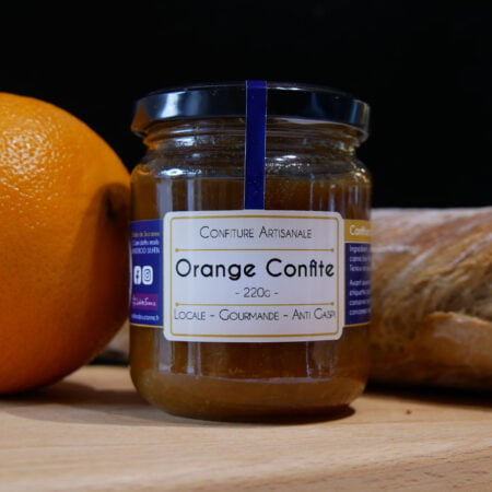 Pot de confiture d'orange sur planche en bois avec pain et oranges