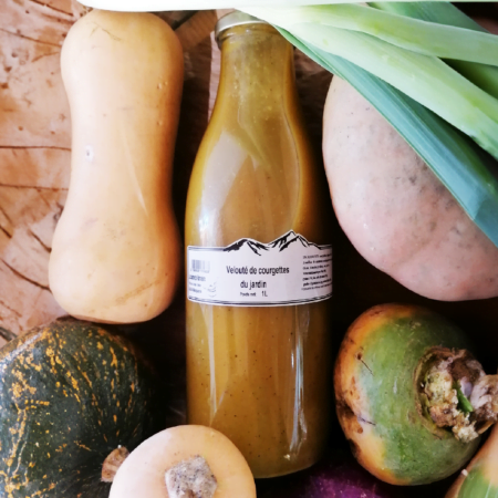 Une bouteille de velouté de courgettes du jardin de 1 Litre de La cuisine de Marcelline, vue de dessus et entouré de légumes