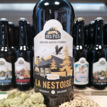 Bouteille de 75cl de bière blonde La Nestoise entourée d'autre bières, de malt et d'orge