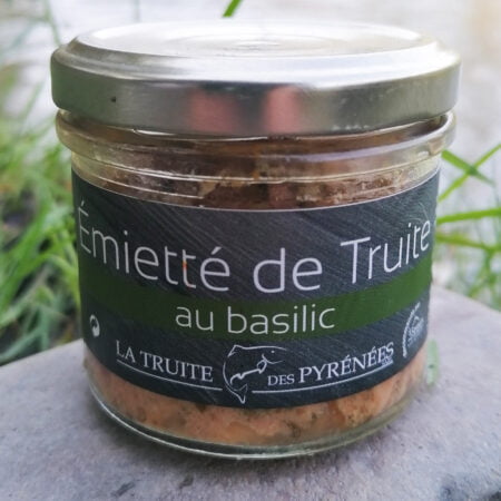 Photo d'un pot d'émietté de truite au basilic de la maison La truite des Pyrénées posé au bords de la rivière.