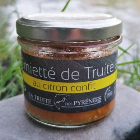 Photo d'un pot d'émietté de truite au citron confit de la maison La truite des Pyrénées posé au bord de la rivière.