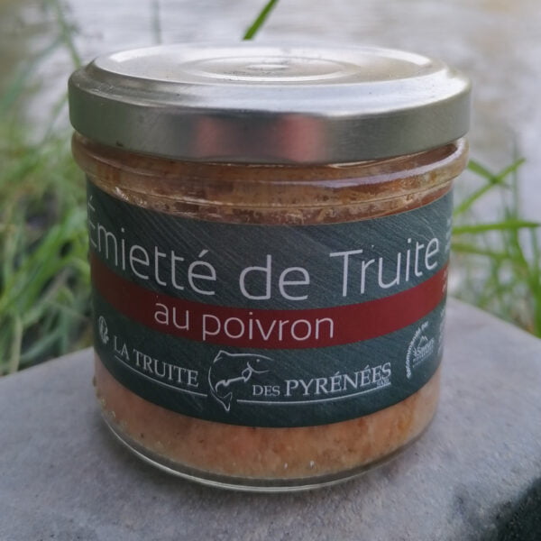 Photo d'un pot d'émietté de truite au poivron de la maison "La truite des Pyrénées" posé au bords de la rivière.