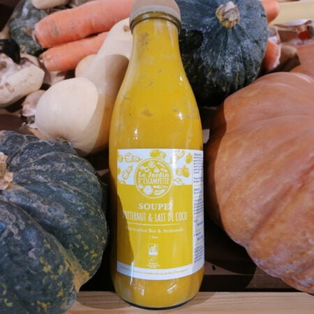 Photo d'une bouteille de 1 litre de Soupe de Butternut et Lait de Coco, Fabrication Bio et Artisanale du Jardin d'escampette entouré de légumes et posé dans une cagette