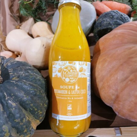 Bouteille de soupe en verre étiquette orange saveur potimarron et lait de coco entourée de divers légumes