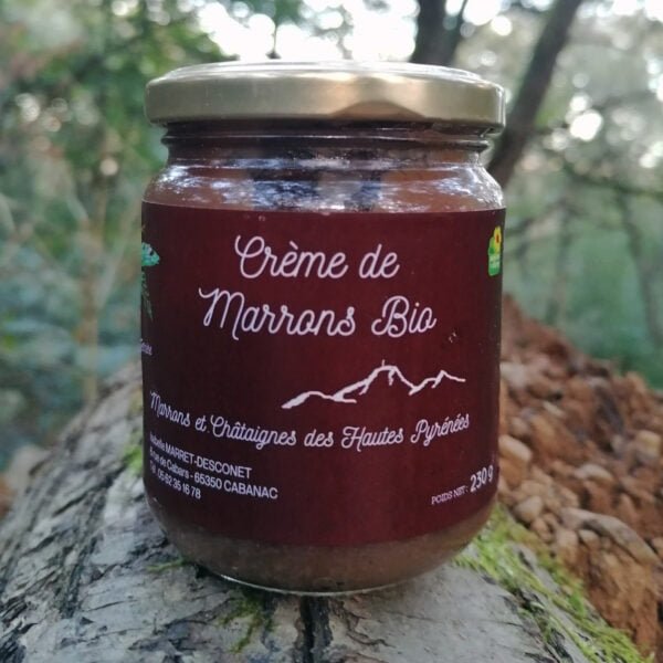 Photo d'un pot de Crème de Marrons Bio des Hautes-Pyrénées posé dans la forêt.