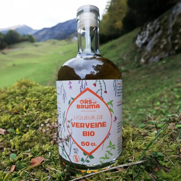 Bouteille de liqueur de Verveine bio de 50 cl posée au pied des montagnes pyrénéennes