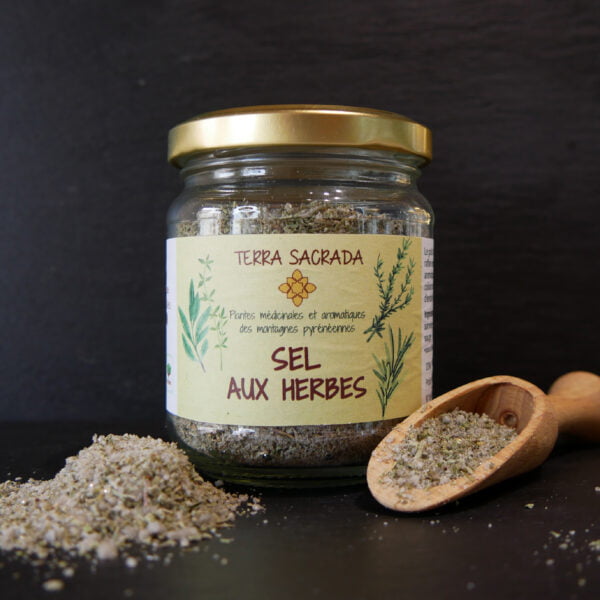 Pot de sel aux herbes d'été de chez terra sacrada producteur des hautes pyrénées avec une cuillère en bois et un petit tas de sel