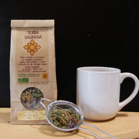 Tisane en sachet sur planche en bois avec échantillon et tasse à coté