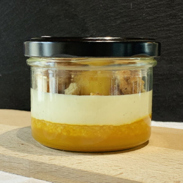 Dessert à la mangue dans un pot en verre avec biscuit et coulis