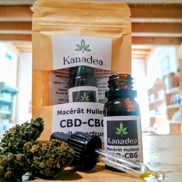 Photo des produits kanadea prise au milieu du magasin Retour aux Sources Bigorre. En premier plan des fleurs de cbd à coté d'un flacon d'huile de cbd-cbg ouvert, une pipette devant et en arriere plan le packaging de cette huile