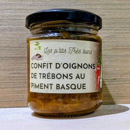 un fond de bois clair, derrière un pot de confit d'oignons de Trébons