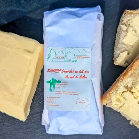 Une planche en ardoise sur laquelle est posé un plaquette de 250g de beurre fermier, à droite des tartines de pain et beurre et à gauche