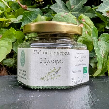 Pot de sel à l'hyope devant des plantes, sur une ardoise noire