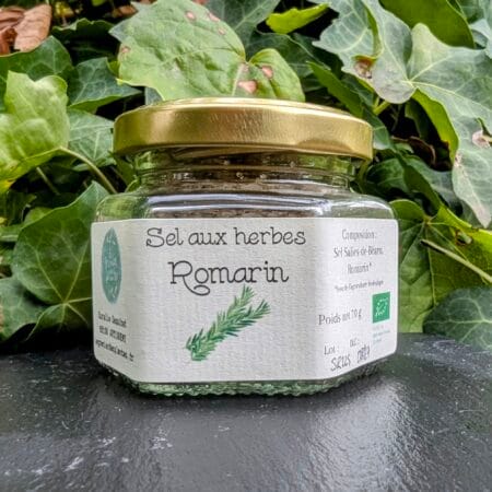 une ardoise de couleur noire sur laquelle est posé un pot de sel au romarin