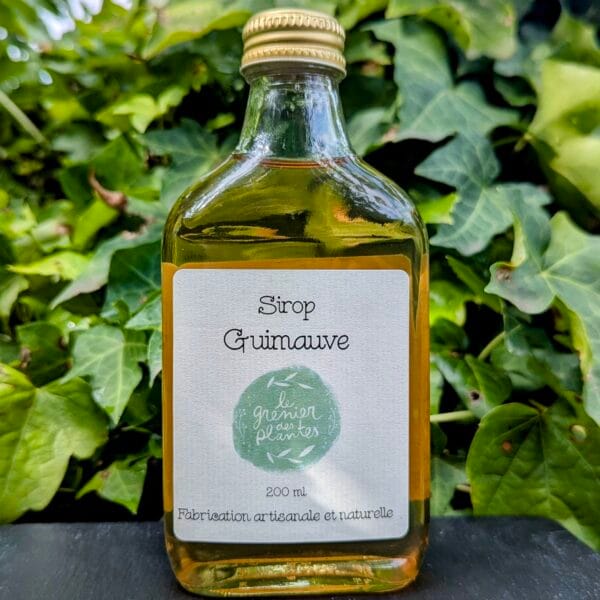 Une jolie flasque de sirop de guimauve, posée sur une ardoise foncée et du lierre vert en fond
