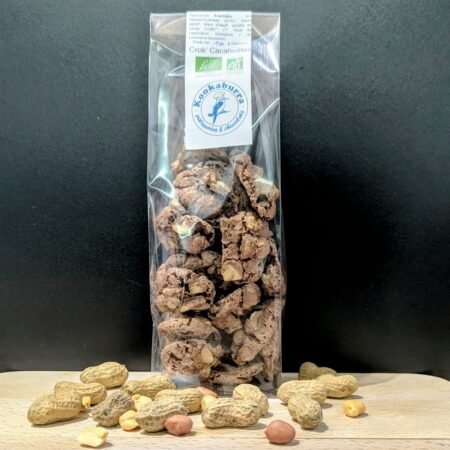 Les Crock'Cacahuètes de Kookaburra devant un fond noir, sur du bois et des cacahuètes devant