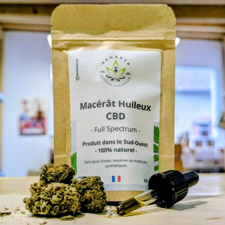 Photo composée de fleurs de cbd en premier plan devant un paquet d'huile de cbd