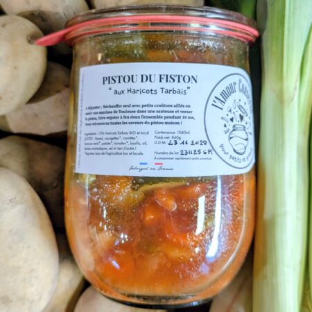 Un tas de légumes sur lequel est posé une conserve de soupe au Pistou de "L'Amour Conserve"
