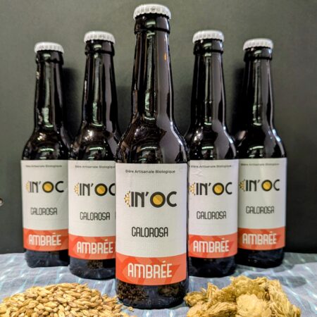 Photo des bières du brasseur indépendant In'Oc, elle sont disposées en pyramides sur un fond noir et accompagnées de malt et de houblon