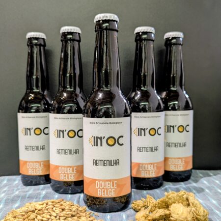 5 bières type Double Belge de chez In'Oc, disposés en pyramide, en premier plan un tas de malt et un de houblon, le tout sur un fond noir